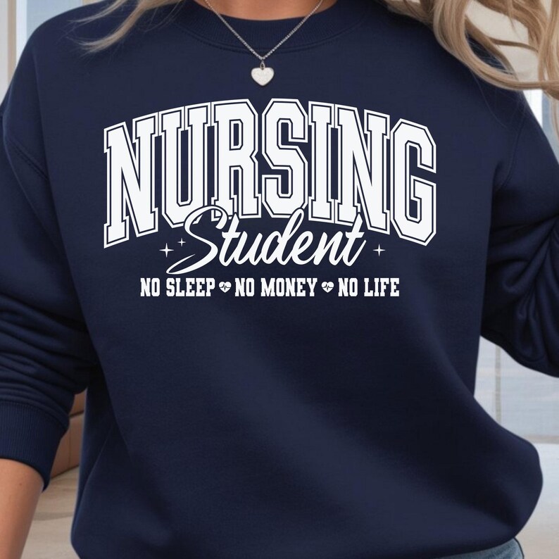 Op de afbeelding: Marineblauwe sweatshirt met de witte tekst "NURSING Student". Daaronder staat de zin "NO SLEEP NO MONEY NO LIFE". De sweatshirt heeft een ronde hals.