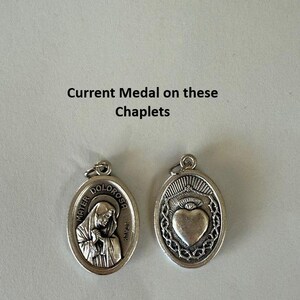 K&ouml;nnte beinhalten: Zwei ovale religi&ouml;se Medaillen aus Silber. Eine zeigt eine Frau mit dem Text "MATER DOLOROSA ITALY". Die andere Medaille hat ein Herzdesign. Der Text "Current Medal on these Chaplets" steht &uuml;ber den Medaillen.