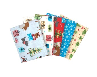 Könnte beinhalten: Ein Set aus sechs Stoffquadraten mit Weihnachtsmotiven in verschiedenen Mustern, darunter ein blaues Quadrat mit einem Rentier, ein rotes Quadrat mit einem Weihnachtsbaum, ein weißes Quadrat mit Geschenken, ein blaues Quadrat mit Sternen, ein weißes Quadrat mit einem Bären und ein beiges Quadrat mit einem Weihnachtsbaum.