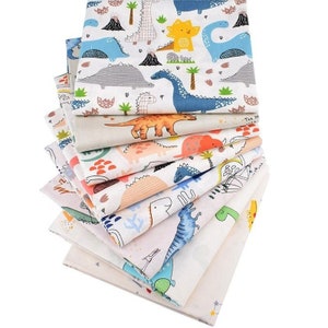 May include: A stack of colorful fabric squares featuring various dinosaur designs. The patterns include dinosaurs in blue, orange, and yellow, along with volcanoes and palm trees on a white background. The fabric appears to be cotton.