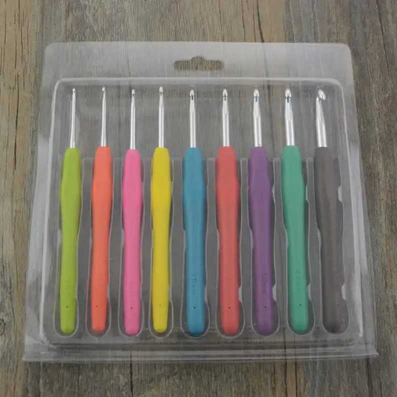 May include: A set of 8 colorful crochet hooks in a clear plastic case. The hooks are arranged in order of size, with the smallest hook on the left and the largest hook on the right. The hooks are made of metal with a plastic handle.