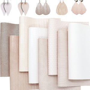 Può includere: Un assortimento di fogli di ecopelle in varie trame e colori, tra cui bianco, beige e motivi strutturati. Sopra, sono esposte diverse paia di orecchini a goccia in colori coordinati.