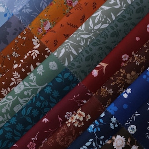 May include: A selection of fabric samples featuring floral designs in a variety of colours. The swatches display patterns with roses, leaves, and other botanical motifs. Colours include blue, green, brown, and red.