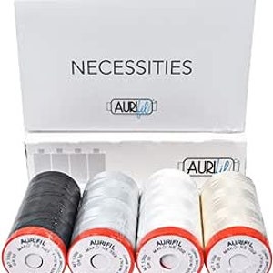Könnte beinhalten: Eine weiße Schachtel mit der Aufschrift "NECESSITIES" enthält vier Spulen Aurifil-Garn. Die Spulen sind schwarz, hellgrau, weiß und cremefarben, jede mit roter Basis. Das Garn ist mit "Mako Ne 50/2" beschriftet.