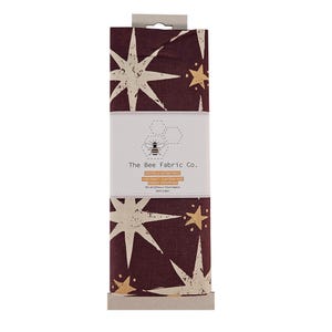 May include: A 2-meter piece of burgundy cotton fabric with a white and gold star print. The fabric is labeled "The Bee Fabric Co." and is intended for craft, quilting, and fabric wrapping.