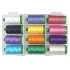May include: A clear plastic organizer filled with spools of colorful thread. The thread colors include white, black, yellow, orange, green, blue, purple, pink, and red. Each spool has green end caps.