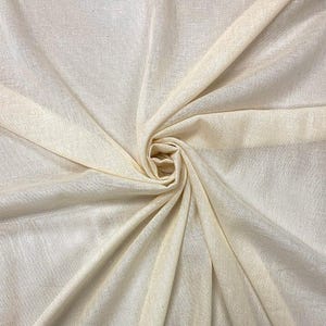 May include: Off-white fabric with a delicate texture, artfully arranged in gentle folds and a central swirl. The fabric looks lightweight and breathable, ideal for clothing or home decor projects.