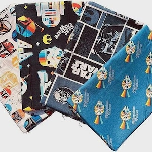 May include: A collection of Star Wars themed fabric squares. Designs include characters like Darth Vader, R2-D2, and the Millennium Falcon. The fabrics feature various colors, including black, blue, white, and orange, with the Star Wars logo.