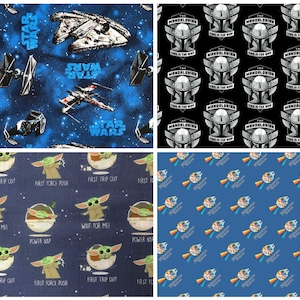 May include: Four different fabric designs featuring Star Wars and The Mandalorian characters. The first design is a blue fabric with stars and spaceships. The second design is a black fabric with a repeating pattern of The Mandalorian's helmet. The third design is a blue fabric with a repeating pattern of Baby Yoda. The fourth design is a blue fabric with a repeating pattern of a spaceship.