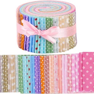 Peut inclure: Un rouleau de bandes de tissu colorées, noué avec un ruban rose. Le tissu présente une variété de couleurs pastel et des pois blancs. Des bandes supplémentaires sont disposées en dessous. Idéal pour les projets de couture et d'artisanat.