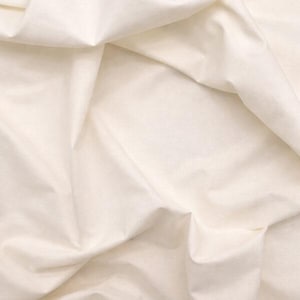 Könnte beinhalten: Nahaufnahme eines cremefarbenen Stoffes mit weichen Falten und subtilen Schatten. Der Stoff wirkt glatt und leicht, mit einer leicht strukturierten Oberfläche. Der Gesamteindruck ist sanfte Bewegung und ein natürlicher, neutraler Ton.