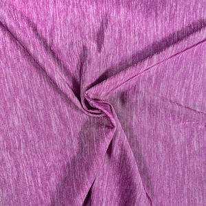 Puede incluir: Tela texturizada de color morado y blanco con un brillo sutil. La tela es suave y elástica, lo que la hace ideal para una variedad de proyectos.