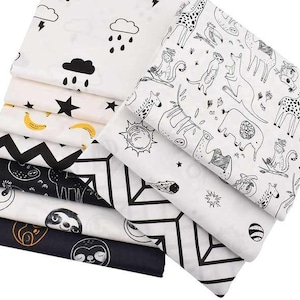 May include: A set of ten fabric squares featuring black and white illustrations of animals, geometric patterns, and weather elements. The fabric squares are white with black designs.