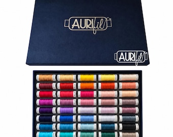 Op de afbeelding: Een donkerblauwe rechthoekige opbergdoos met het witte AuriFil-logo op het deksel. De open doos bevat een raster van vijfenveertig individuele klossen naaigaren in een breed kleurenspectrum, gerangschikt in vijf rijen van negen klossen elk.