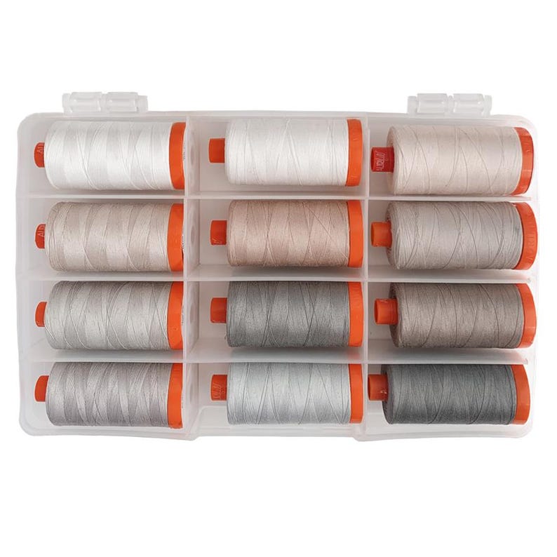 May include: A clear plastic storage box with 12 spools of thread. The spools are arranged in three rows of four. The spools are white, beige, and gray.