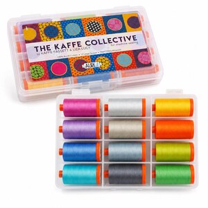 May include: A set of 12 large spools of 100% cotton machine sewing thread by The Kaffe Collective, presented in a clear plastic storage case. The spools feature a vibrant array of colors including magenta, silver, yellow, purple, orange, blue, and green.