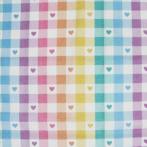 May include: White fabric with a rainbow gingham pattern and small white hearts. The fabric is a cotton blend.