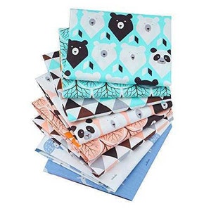 Puede incluir: Un conjunto de diez cuadrados de tela con diferentes estampados de animales. Los estampados incluyen osos, pandas y b&uacute;hos. Las telas son en tonos de azul, rosa y blanco.