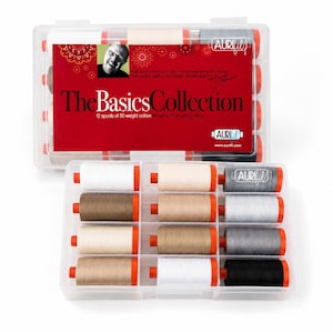 May include: A clear plastic storage case containing 12 spools of 50 weight cotton thread in neutral colours. The red label reads The Basics Collection and features the Aurifil logo. Each spool has orange ends and is organised in a grid.