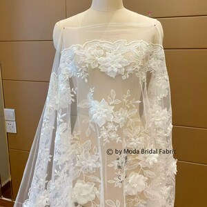Tessuto in pizzo con fiori 3d e paillettes color avorio, larghezza 130 cm, venduto al metro
