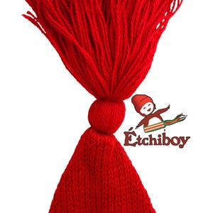 May include: A red knitted hat with a large red tassel. The hat is made of a soft, warm material and is perfect for keeping your head warm in the winter.