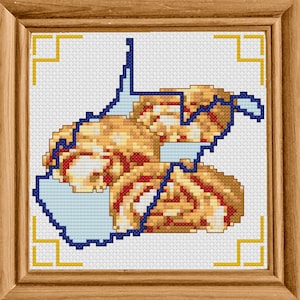 May include: A cross-stitch pattern of the state of West Virginia, outlined in blue, with a gold and red design inside the state shape.