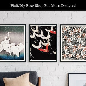 May include: Three framed prints with Japanese-inspired designs. The left print features a group of white egrets against a blue and white background. The centre print shows a group of red and white cranes flying against a black background. The right print features a repeating pattern of white flowers with black and brown accents.