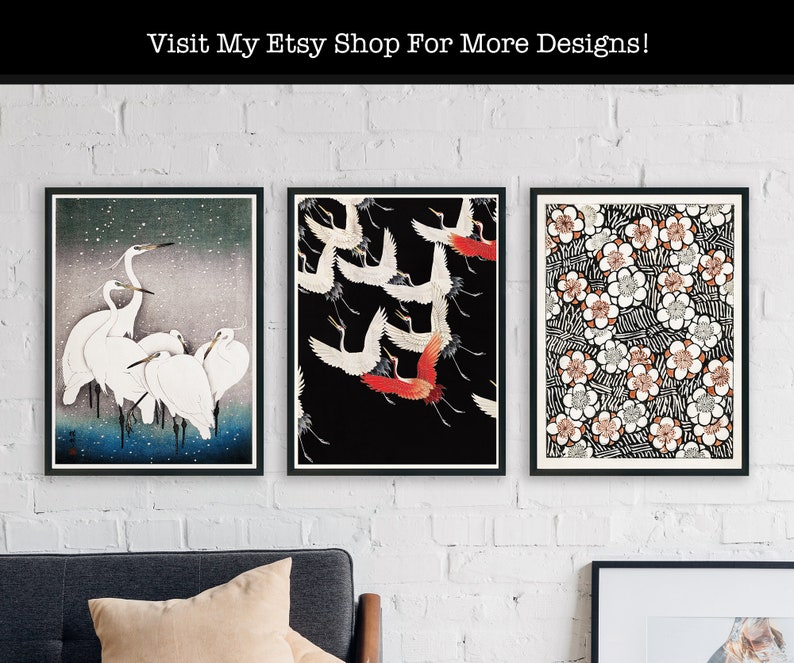 May include: Three framed prints with Japanese-inspired designs. The left print features a group of white egrets against a blue and white background. The centre print shows a group of red and white cranes flying against a black background. The right print features a repeating pattern of white flowers with black and brown accents.
