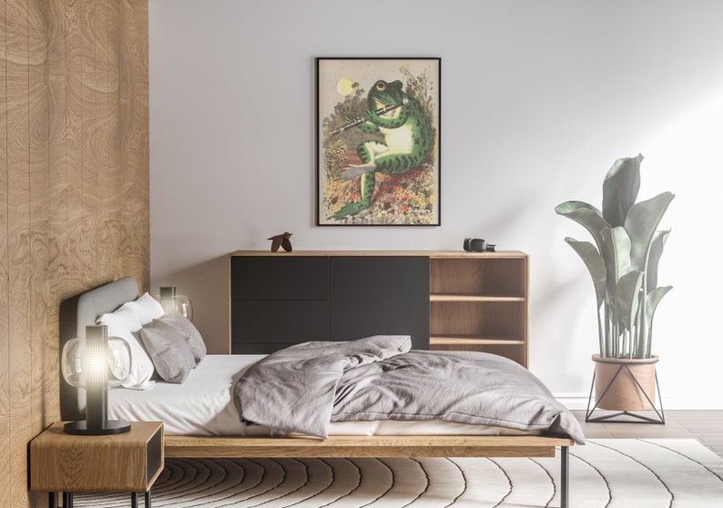 K&ouml;nnte beinhalten: Ein Schlafzimmer-Interieur mit einem Bett, einem Nachttisch, einer Lampe, einer Kommode, einer Pflanze und einem gerahmten Druck eines Frosches, der Fl&ouml;te spielt.