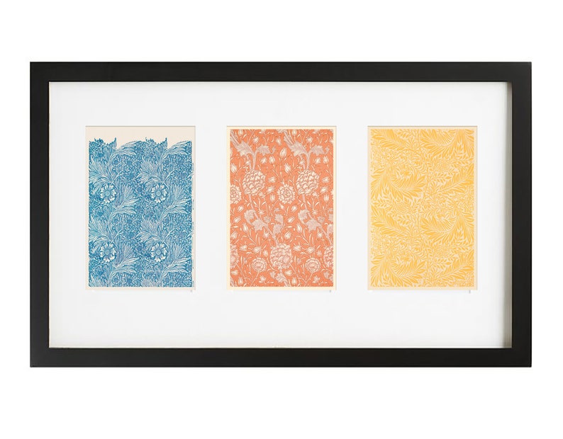 Pu&ograve; includere: Una cornice nera con tre stampe a motivi diversi all'interno. Le stampe sono in tonalit&agrave; di blu, arancione e giallo.