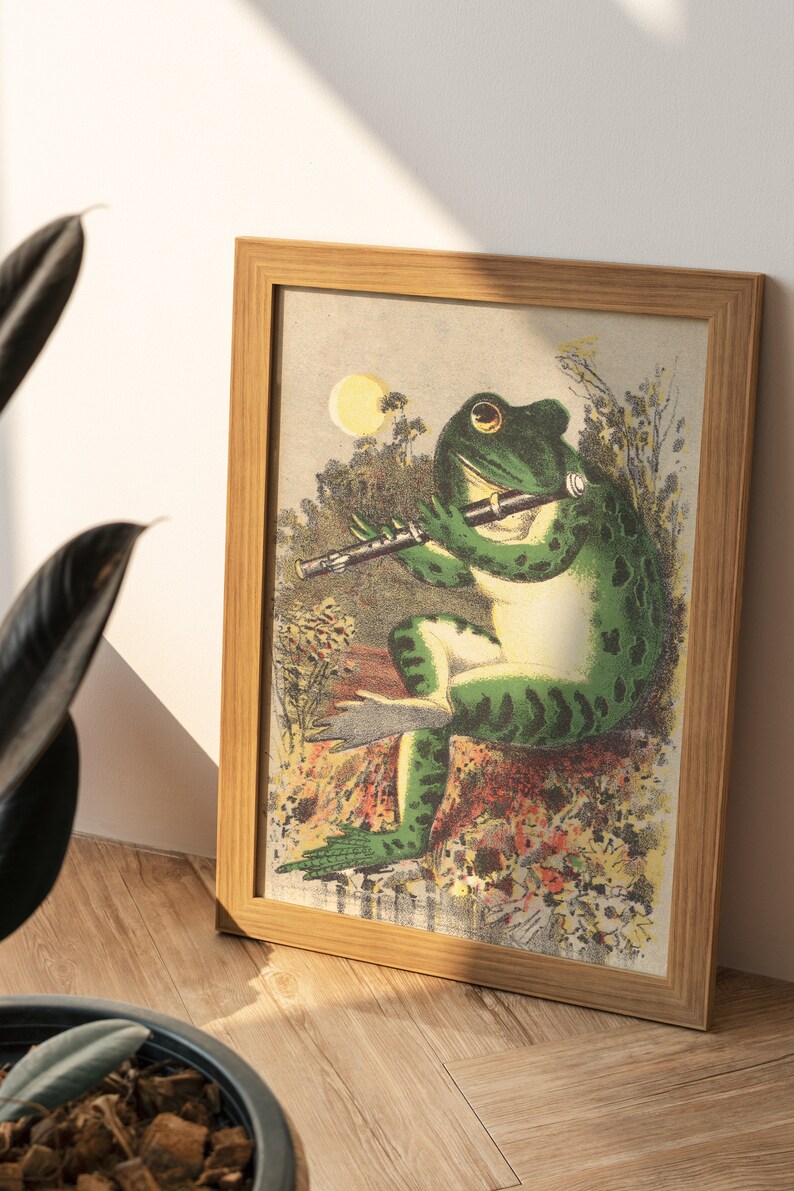 K&ouml;nnte beinhalten: Eine gerahmte Illustration eines gr&uuml;nen Frosches, der in einer Waldlandschaft Fl&ouml;te spielt. Der Frosch sitzt mit gekreuzten Beinen und geschlossenen Augen auf einem Stein. Der Hintergrund ist ein &uuml;ppiger gr&uuml;ner Wald mit einem leuchtend gelben Mond am Himmel.