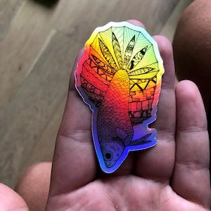 Puede incluir: Una pegatina hologr&aacute;fica de un pez con un dise&ntilde;o intrincado en blanco y negro. El pez est&aacute; delineado en negro y tiene un degradado de colores de rojo a azul.
