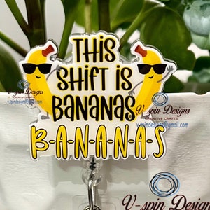 May include: A badge reel with the phrase "This Shift is Bananas" in black and yellow lettering, featuring cartoon bananas wearing sunglasses. A charm of sunglasses with a yellow glitter background hangs below.