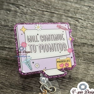 May include: A purple glitter badge reel with the text "WILL CONTINUE TO MONITOR" and the hashtag "#NURSELIFE". The reel has a daisy charm and a purple glitter button. The background is a dark wood grain.