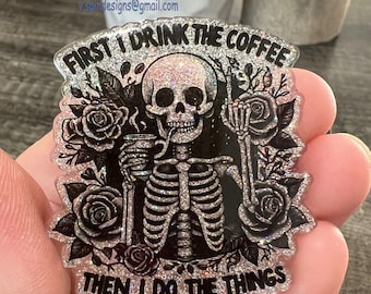 May include: A clear faceplate with a glittery background featuring a black skeleton holding a cup of coffee. The text "FIRST I DRINK THE COFFEE THEN I DO THE THINGS" is written around the skeleton. The word "Faceplate" is written in white letters at the bottom of the image.