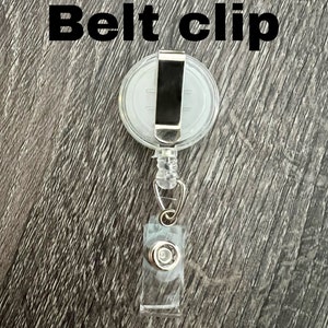Peut inclure: Un porte-badge r&eacute;tractable en plastique transparent avec un clip de ceinture en m&eacute;tal argent&eacute;. Le clip est fix&eacute; &agrave; un pivot en plastique transparent. Le porte-badge a un bouton en plastique transparent sur le bas.