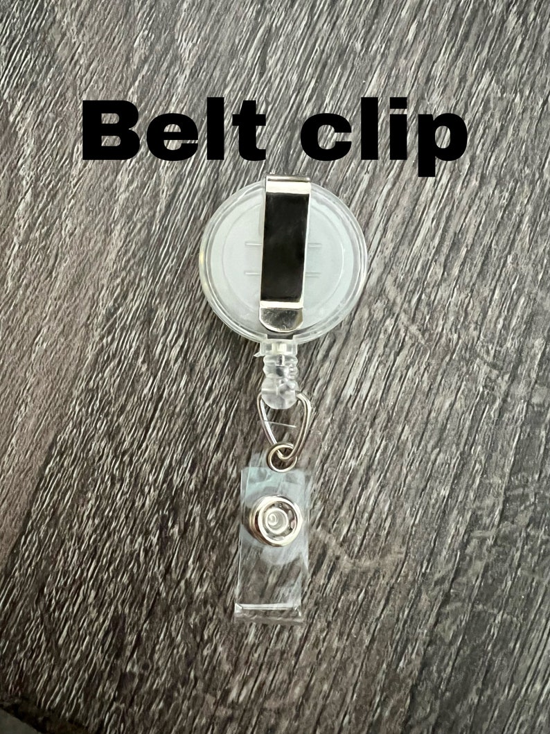 Peut inclure: Un porte-badge r&eacute;tractable en plastique transparent avec un clip de ceinture en m&eacute;tal argent&eacute;. Le clip est fix&eacute; &agrave; un pivot en plastique transparent. Le porte-badge a un bouton en plastique transparent sur le bas.