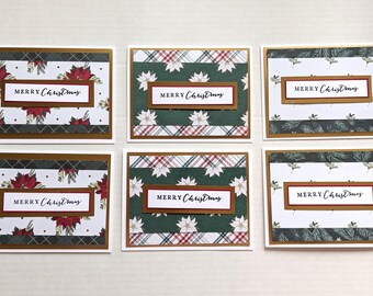 May include: Six rectangular greeting cards arranged in two rows. Each card features a central white label with the text Merry Christmas in black script, layered over gold, red, and patterned paper backgrounds with poinsettia and pine motifs.