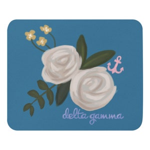May include: A blue background with two white roses, green leaves, and yellow flowers. A pink anchor is in the upper right corner. The text "delta gamma" is written in purple at the bottom of the image.