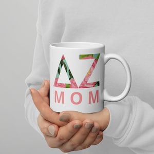 May include: White ceramic mug with a pink floral design and the text "AZ MOM" in pink letters.