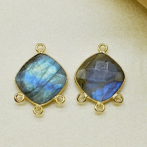 Op de afbeelding: Twee goudkleurige metalen connector charms met een vierkante labradorite edelsteen in het midden. Elke charm heeft drie lussen om aan sieraden te bevestigen.