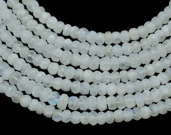 May include: A strand of white moonstone beads, faceted and polished, with a subtle iridescent sheen. The beads are strung on a clear thread and are approximately 6mm in diameter.