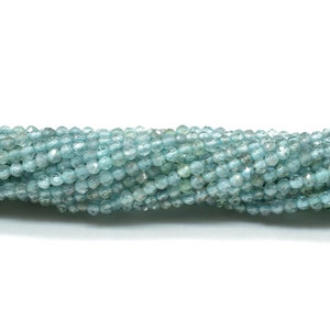 May include: A strand of light blue aquamarine beads. The beads are faceted and have a slightly irregular shape.