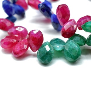 Peut inclure: Un brin de perles de pierres précieuses facettées dans des tons de vert, rose et bleu. Les perles sont en forme de goutte et ont une finition polie.