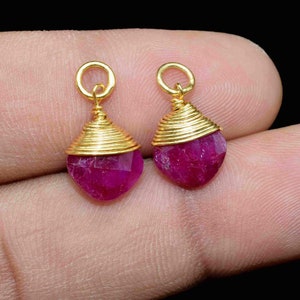 Puede incluir: Dos pendientes de rubí en forma de lágrima envueltos en oro.