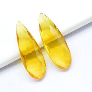 Può includere: Due orecchini di cristallo giallo a forma di lacrima.