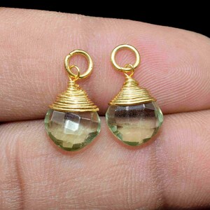 May include: A pair of green gemstone earrings with a wire-wrapped design, finished in gold.