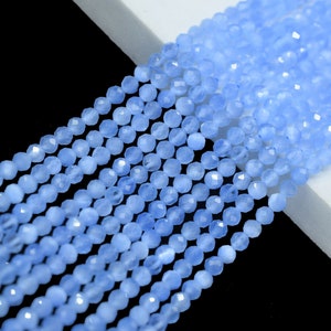 May include: A strand of light blue faceted gemstone beads. The beads are round and have a smooth, polished finish.