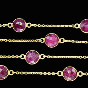 以下が含まれることがあります： 丸いファセットカットのルビー色の石が複数並んだ、複数の鎖からなるゴールドチェーンネックレスです。