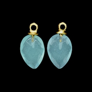May include: Two light blue teardrop-shaped gemstone pendants with gold-colored metal loops at the top.
